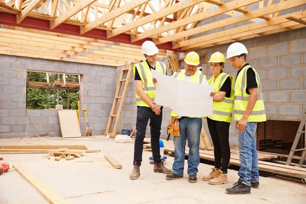 Crew reading a set of approved plans on a job site