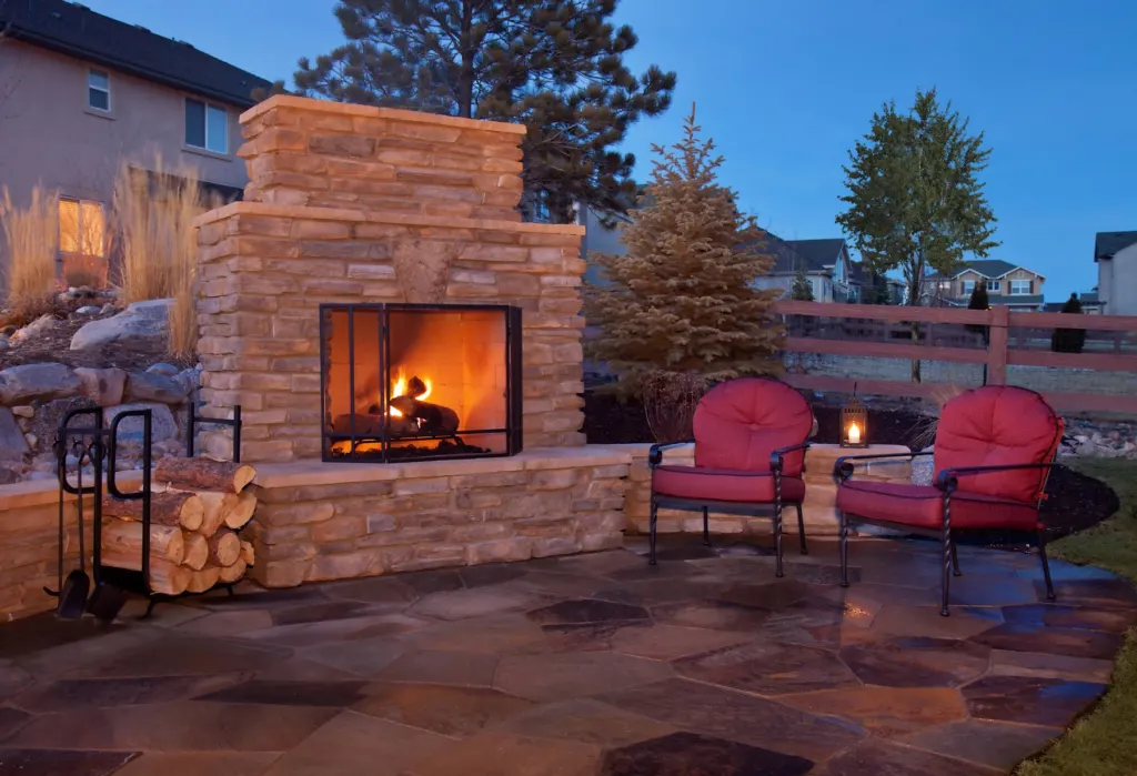 Flagstone patio with a stone outdoor fireplace and seating
