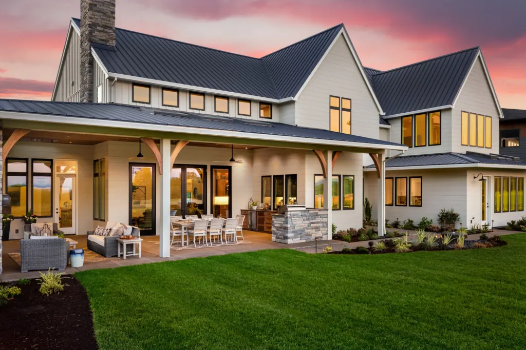 Covered rear porch with an outdoor kitchen at dusk