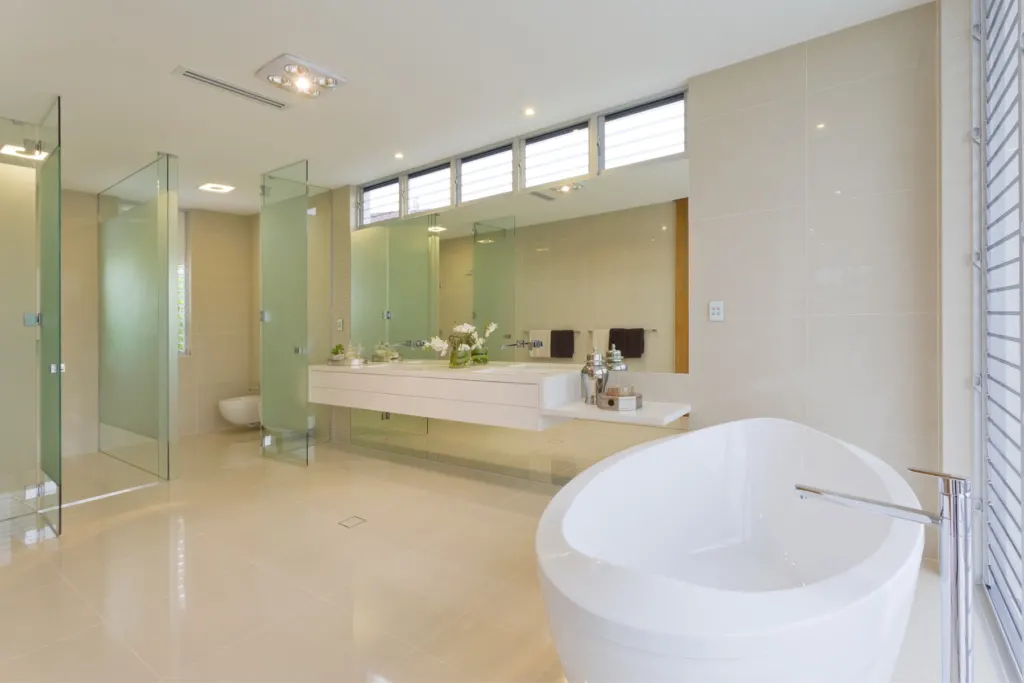 Travertine-floored bathroom with a freestanding oval tub