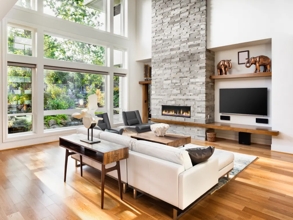 Living room with wide-plank wood flooring and a stone fireplace